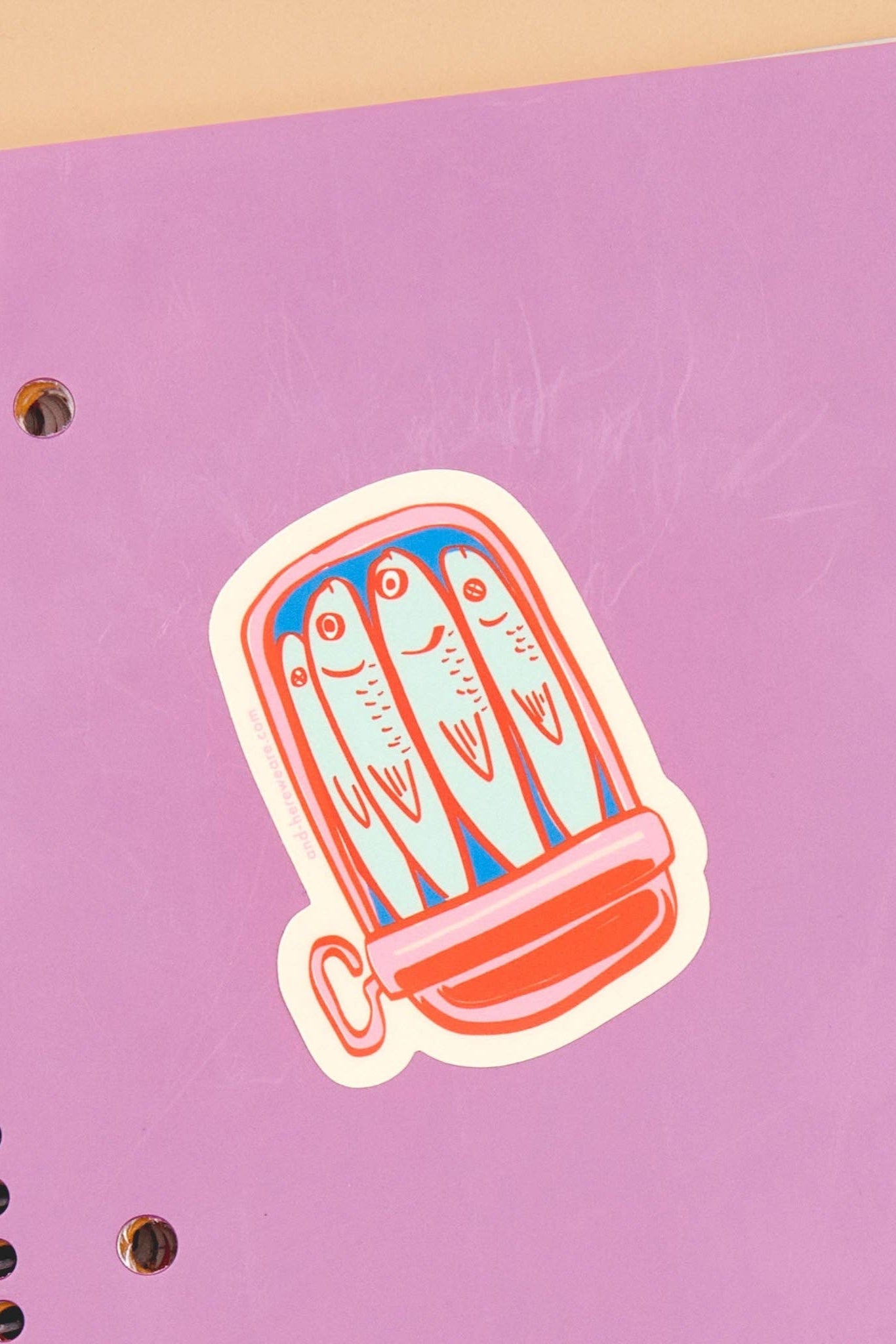 Die-cut vinyl sticker depicting a colorful illustration of sardines in a tin can, featuring artwork by Meghan Hopkins Sokor. The sticker measures approximately 3 inches, is waterproof, durable, and suitable for outdoor use.