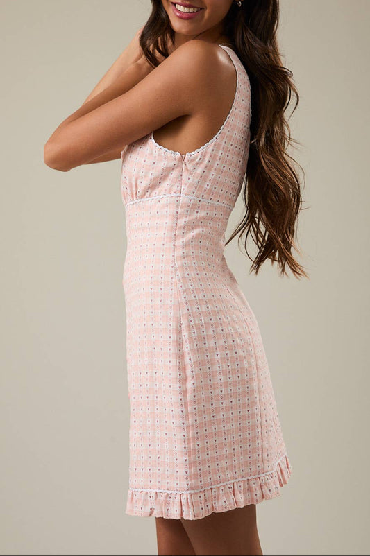 Woman wearing a pink dress against a plain background