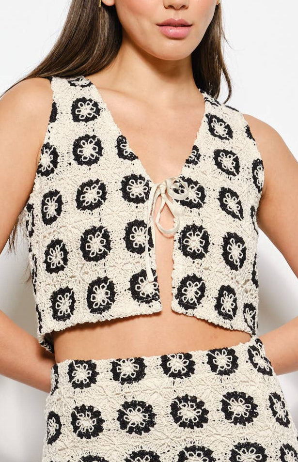 Woman wearing a patterned sleeveless top and skirt set on a white background