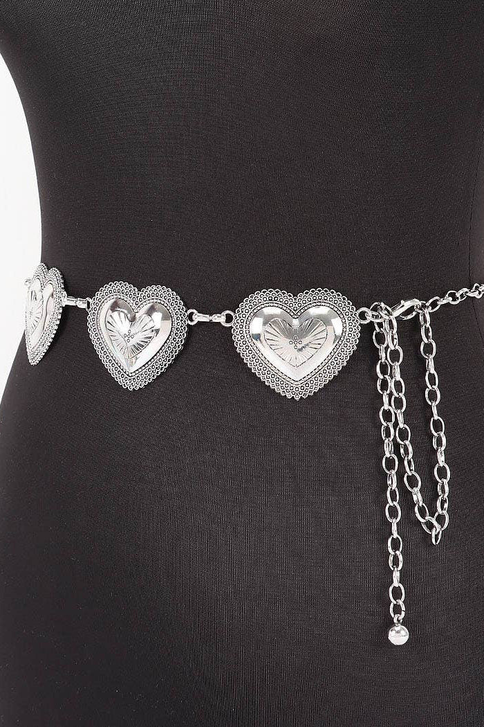 Silver heart-shaped belt with chain on a black dress form against a white background