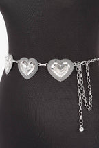 Silver heart-shaped belt with chain on a black dress form against a white background
