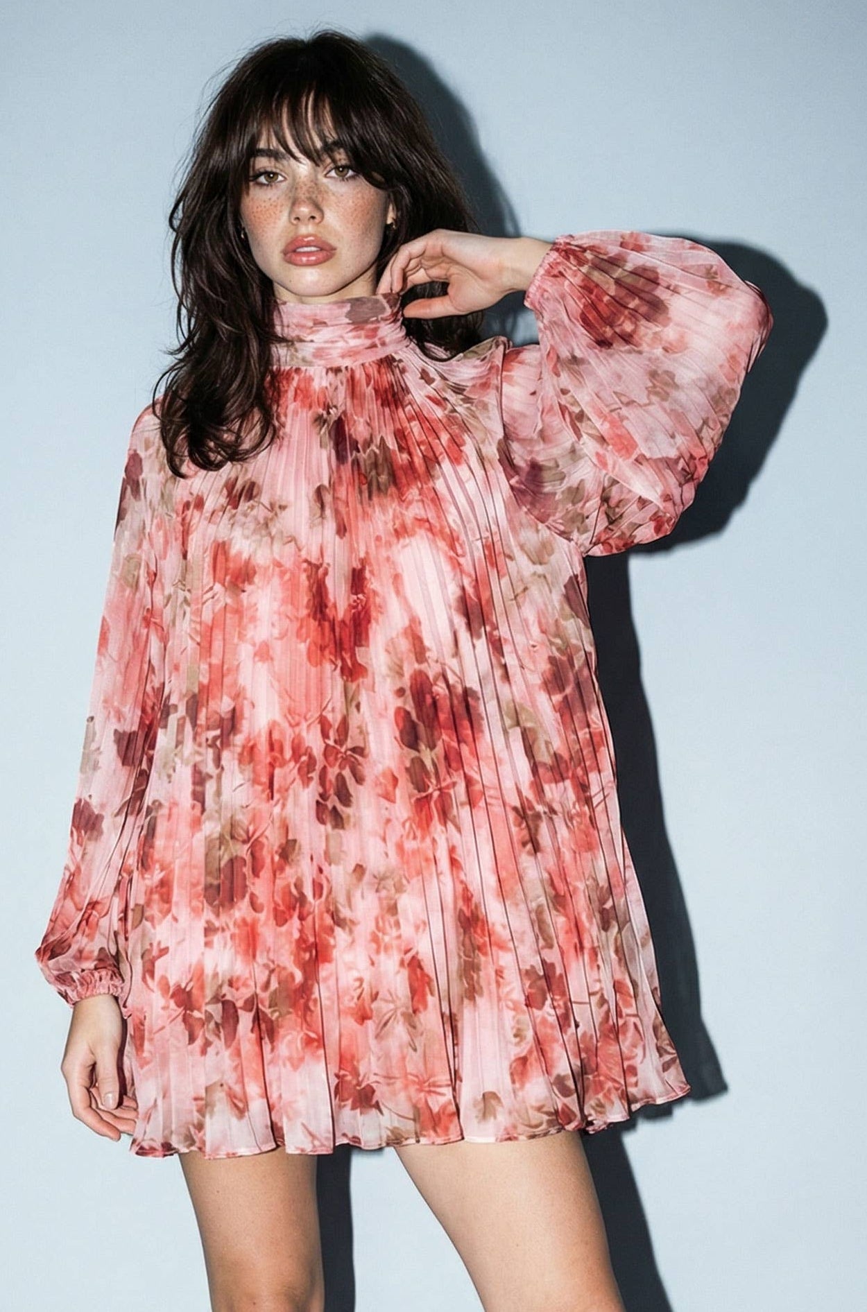 Woman wearing a floral dress against a plain background