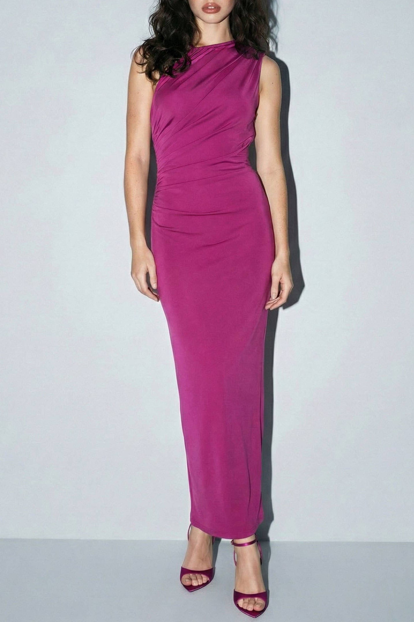 Woman wearing a pink dress against a plain background