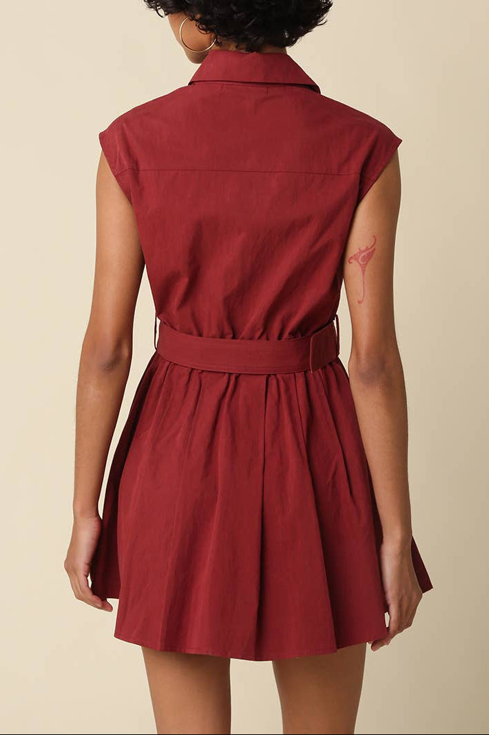 Red sleeveless dress worn by a person on a beige background