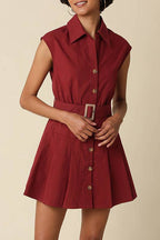 Woman wearing a red dress with a belt on a beige background