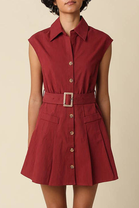 Woman wearing a red dress with a belt on a beige background