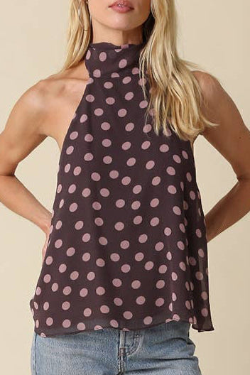 Woman wearing a patterned top and jeans on a beige background