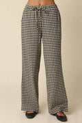 Black and white gingham wide-leg pants with a drawstring waist, shown on a model from the waist down against a plain beige background.