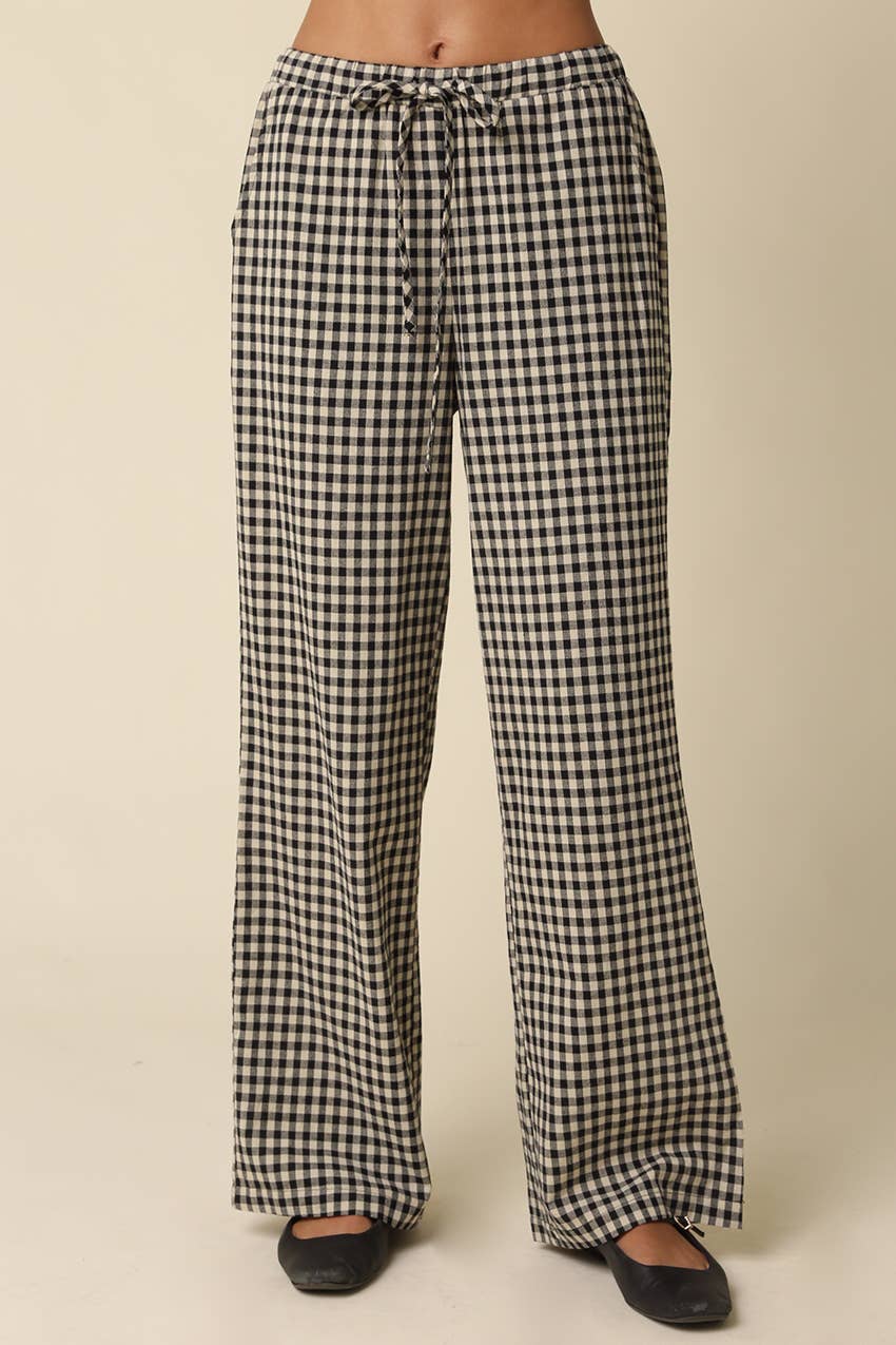 Black and white gingham wide-leg pants with a drawstring waist, shown on a model from the waist down against a plain beige background.