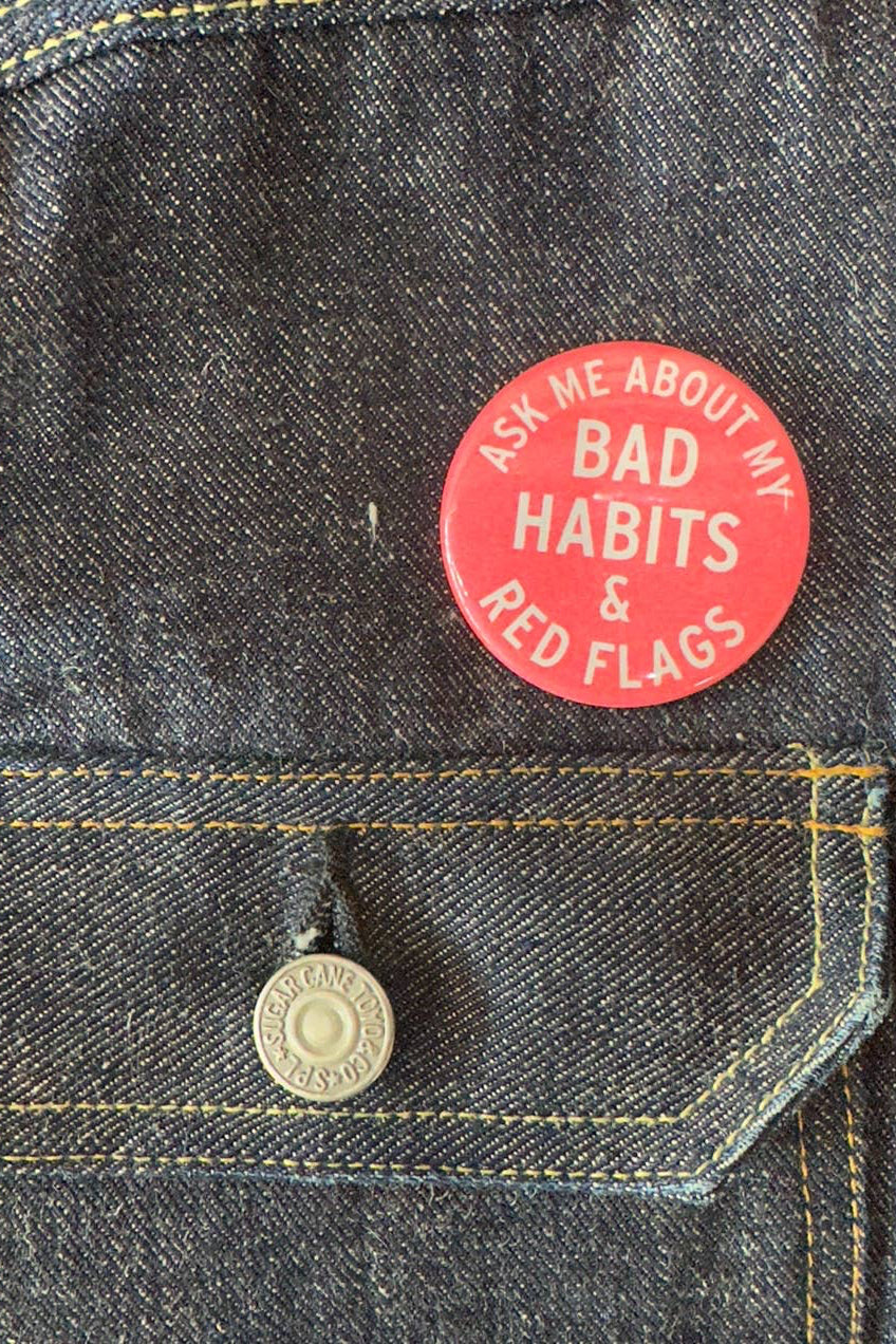 Red button with text on a denim jacket