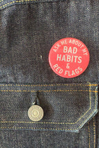 Red button with text on a denim jacket