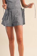 Person wearing a striped skort with white sneakers on a beige background
