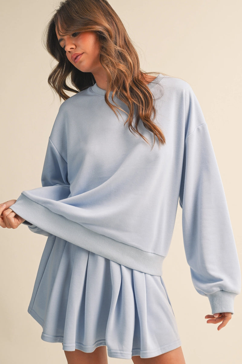 Woman wearing a light blue dress against a beige background