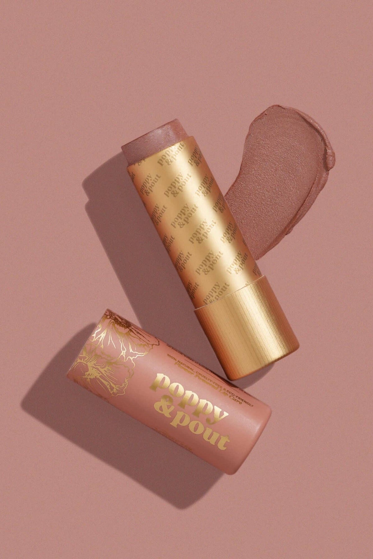 Two makeup products with gold and pink packaging on a matching background