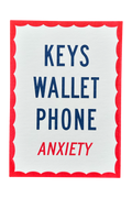 A square white card or sign with a red scalloped border, featuring the words 'KEYS WALLET PHONE' in dark blue and 'ANXIETY' in red, centered on a light gray background.