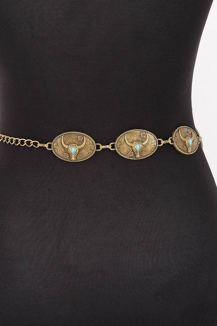 An antique bronze western-style belt with three oval engraved medallions set with small turquoise stones, displayed on a black mannequin torso.
