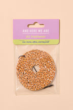 Air freshener with packaging labeled 'And Here We Are' on a beige background