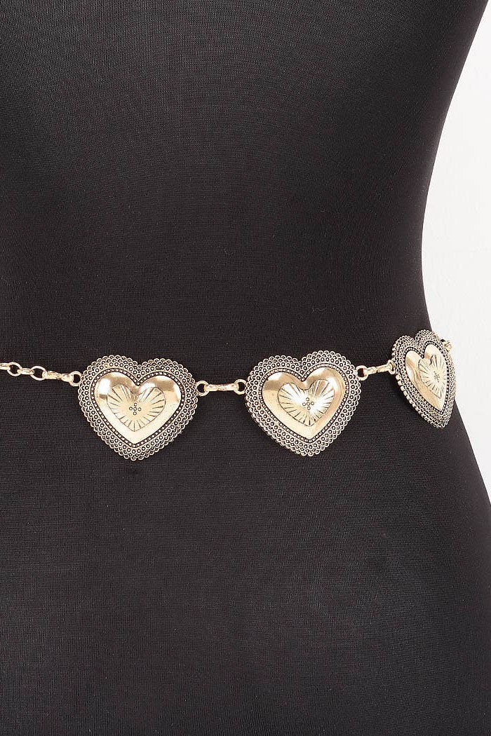 Gold heart-shaped belt on a black mannequin against a white background