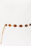 Gold belt with brown beads on a white background