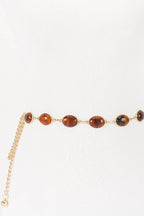 Gold belt with brown beads on a white background
