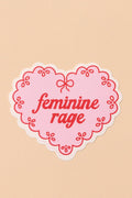 Heart-shaped sticker with 'feminine rage' text on a beige background