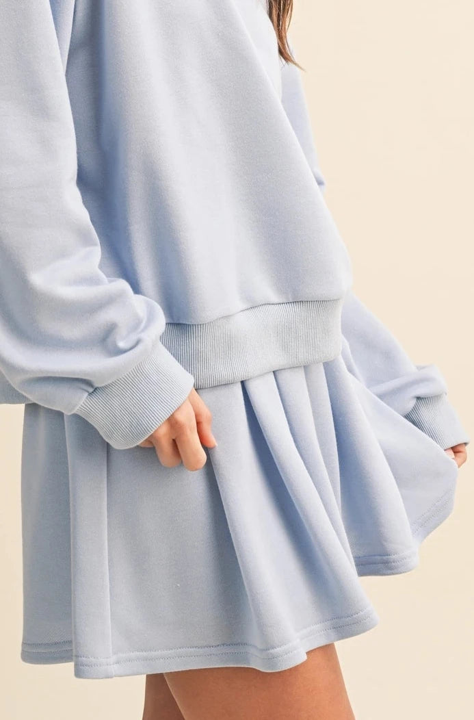 Woman wearing a light blue skirt against a beige background