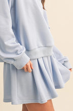 Woman wearing a light blue skirt against a beige background