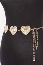 A gold-toned chain belt with three textured heart-shaped links and dangling chain accents, displayed on a black mannequin torso against a white background.
