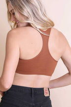 Woman wearing a brown ribbed crop top against a beige background