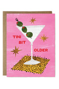 Greeting card with a martini glass and olives on a pink background