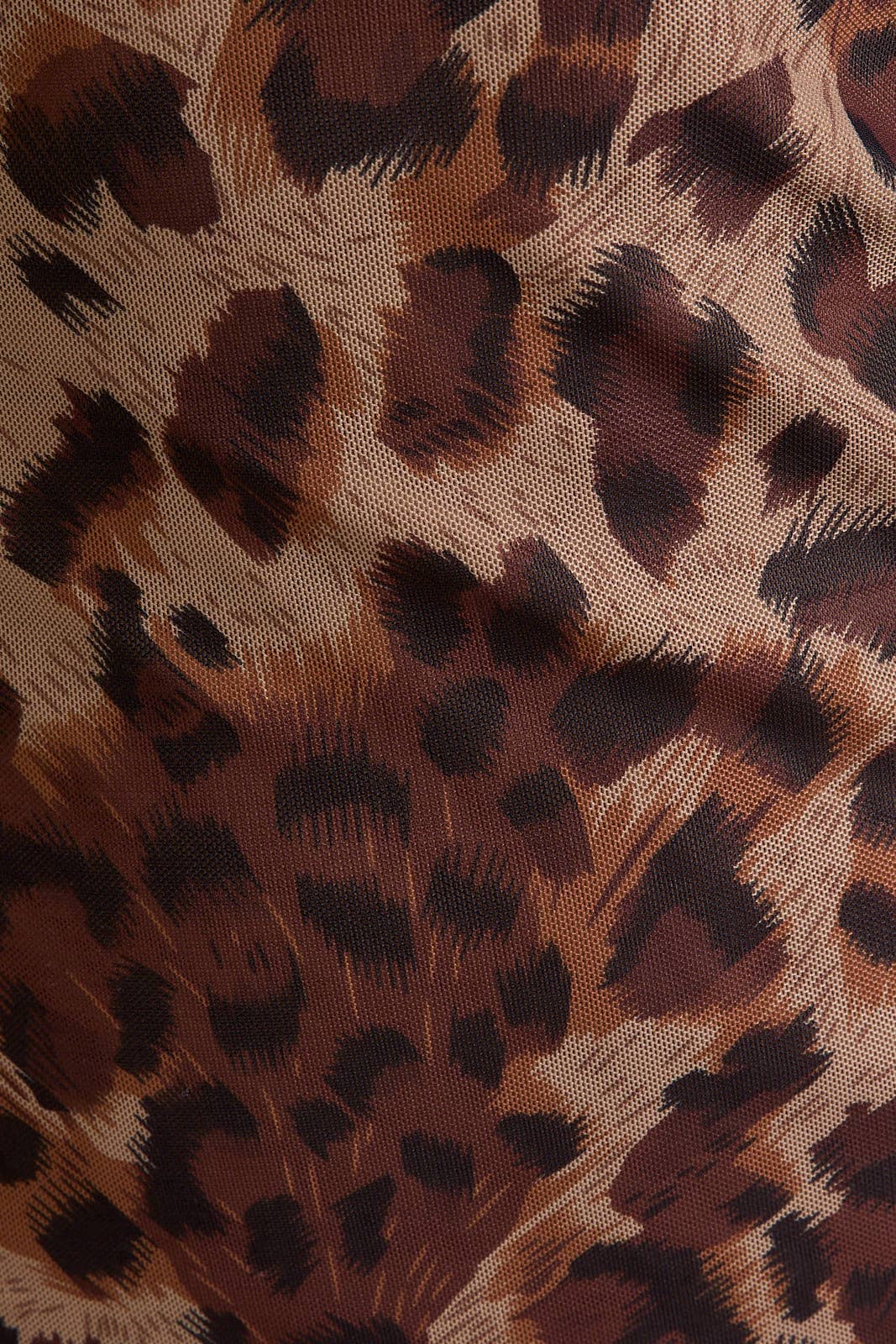 Close-up of leopard print fabric with brown and black spots.