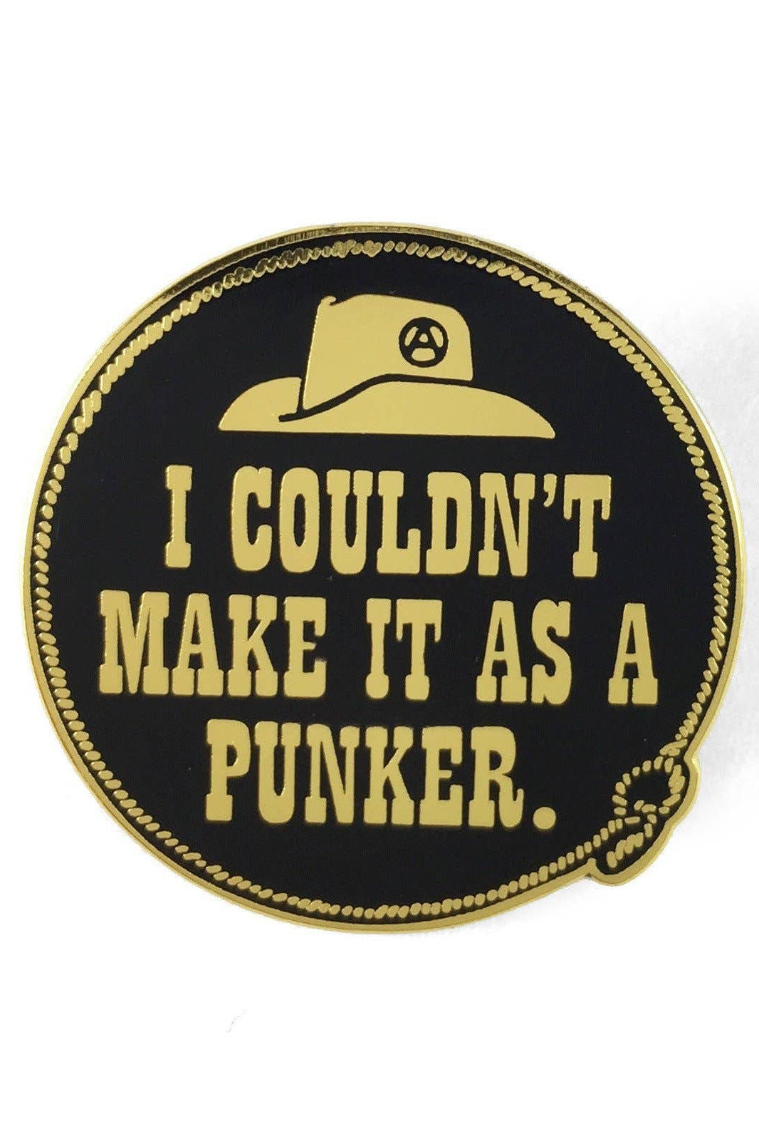 A circular enamel pin with a black face, gold border, and gold text reading 'I COULDN'T MAKE IT AS A PUNKER.' A gold hat with a peace symbol is shown above the text.