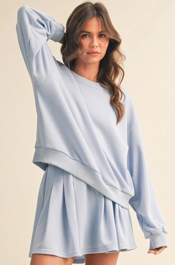 Woman wearing a light blue outfit on a beige background