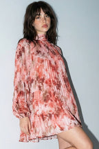 Woman wearing a floral dress and high heels against a plain background