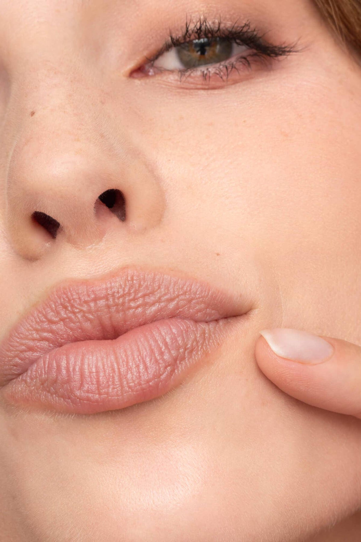 Close-up of a woman's face with a finger near her mouth