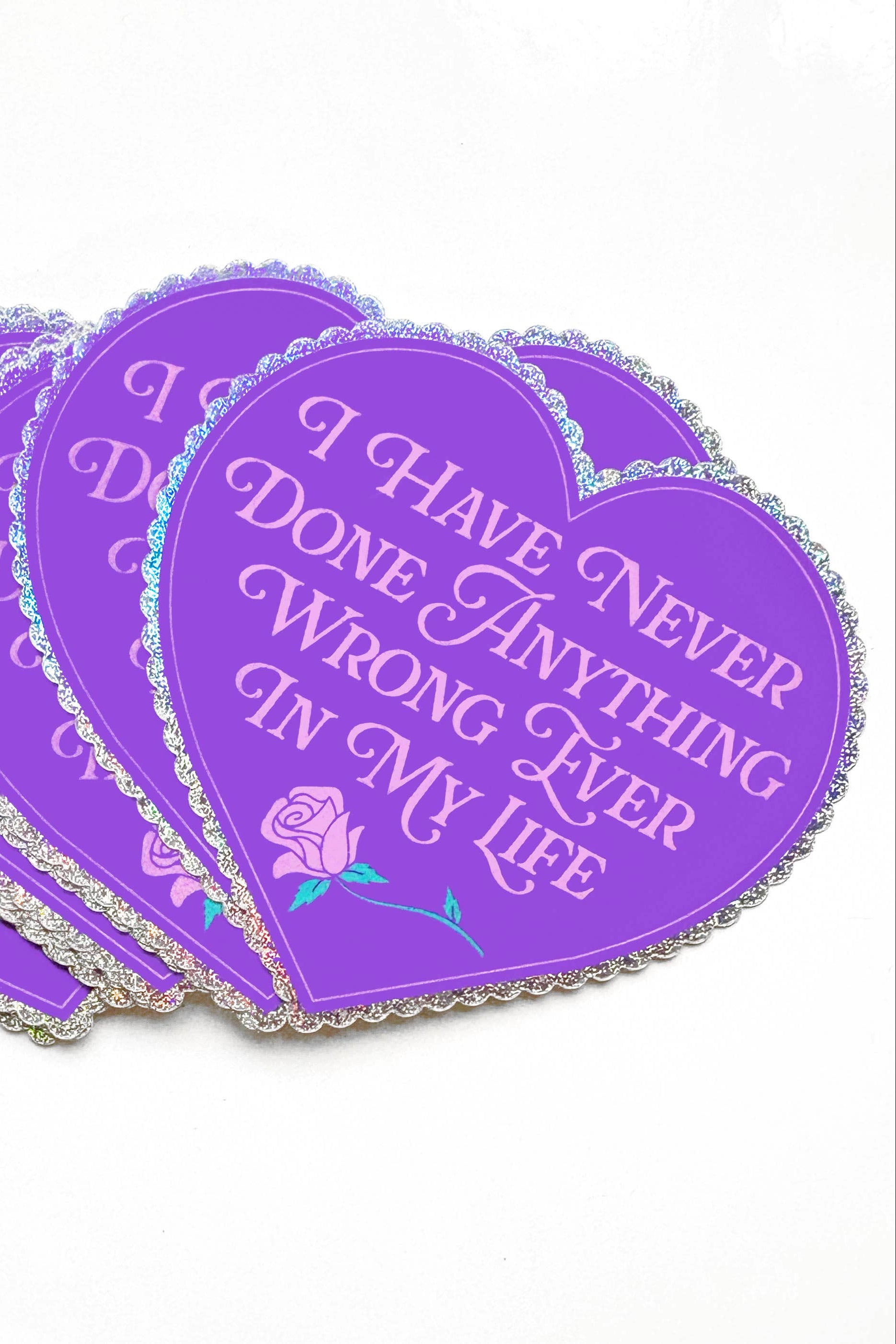 Purple heart-shaped stickers with text and a rose design on a white background