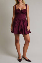 Woman wearing a burgundy dress against a plain background