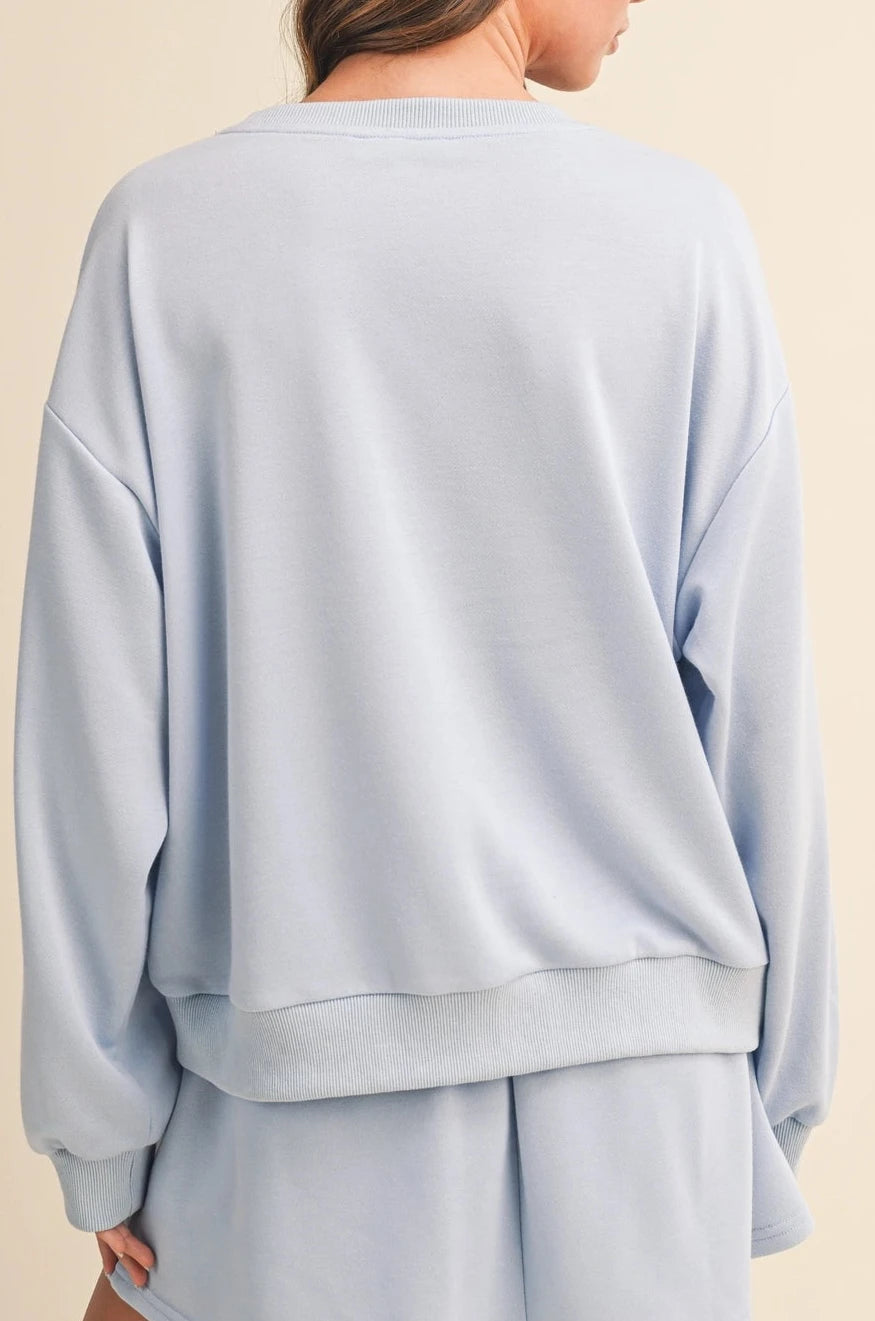 Light blue sweatshirt and shorts set on a beige background