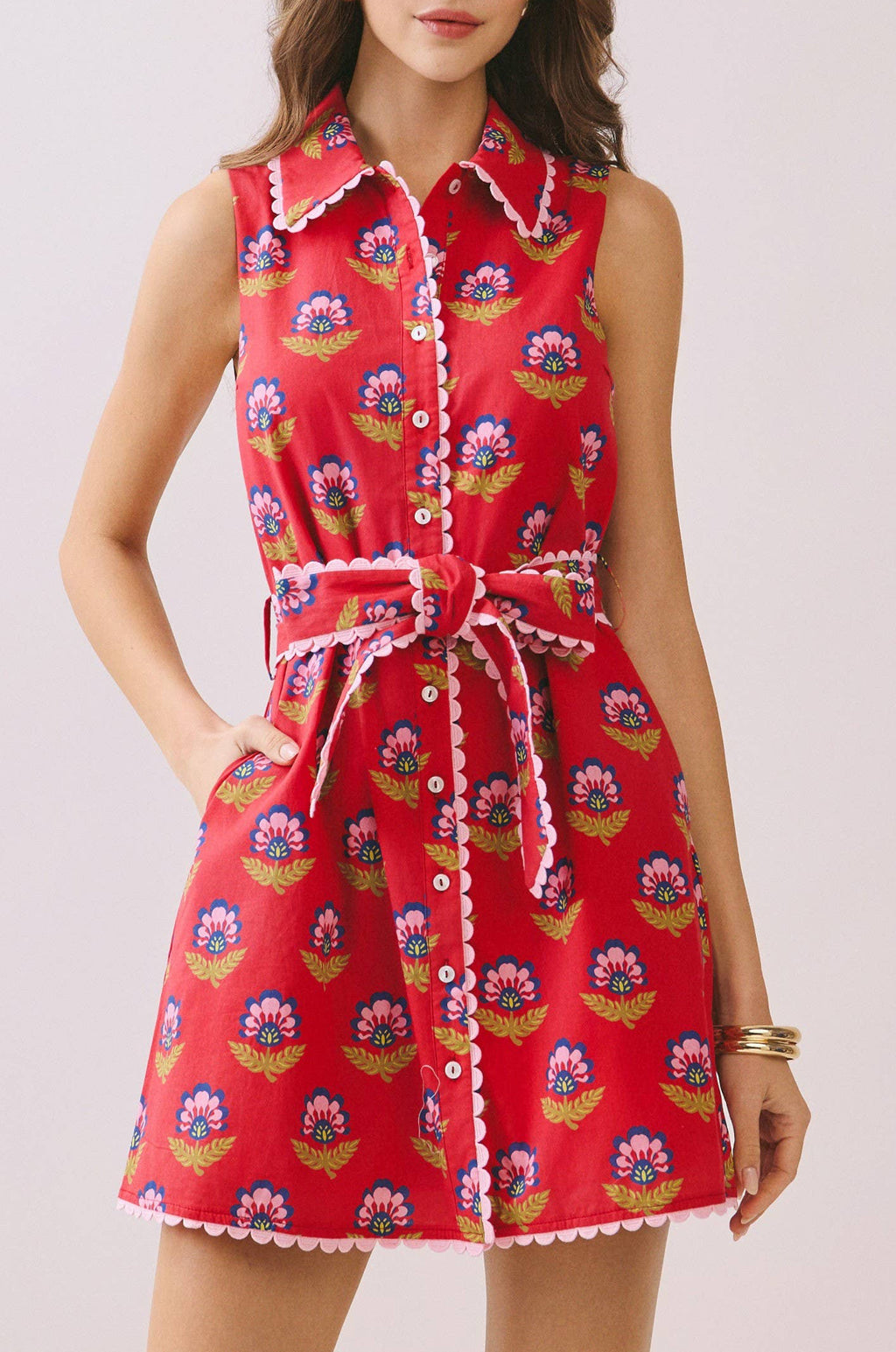 Woman wearing a red floral dress on a light background