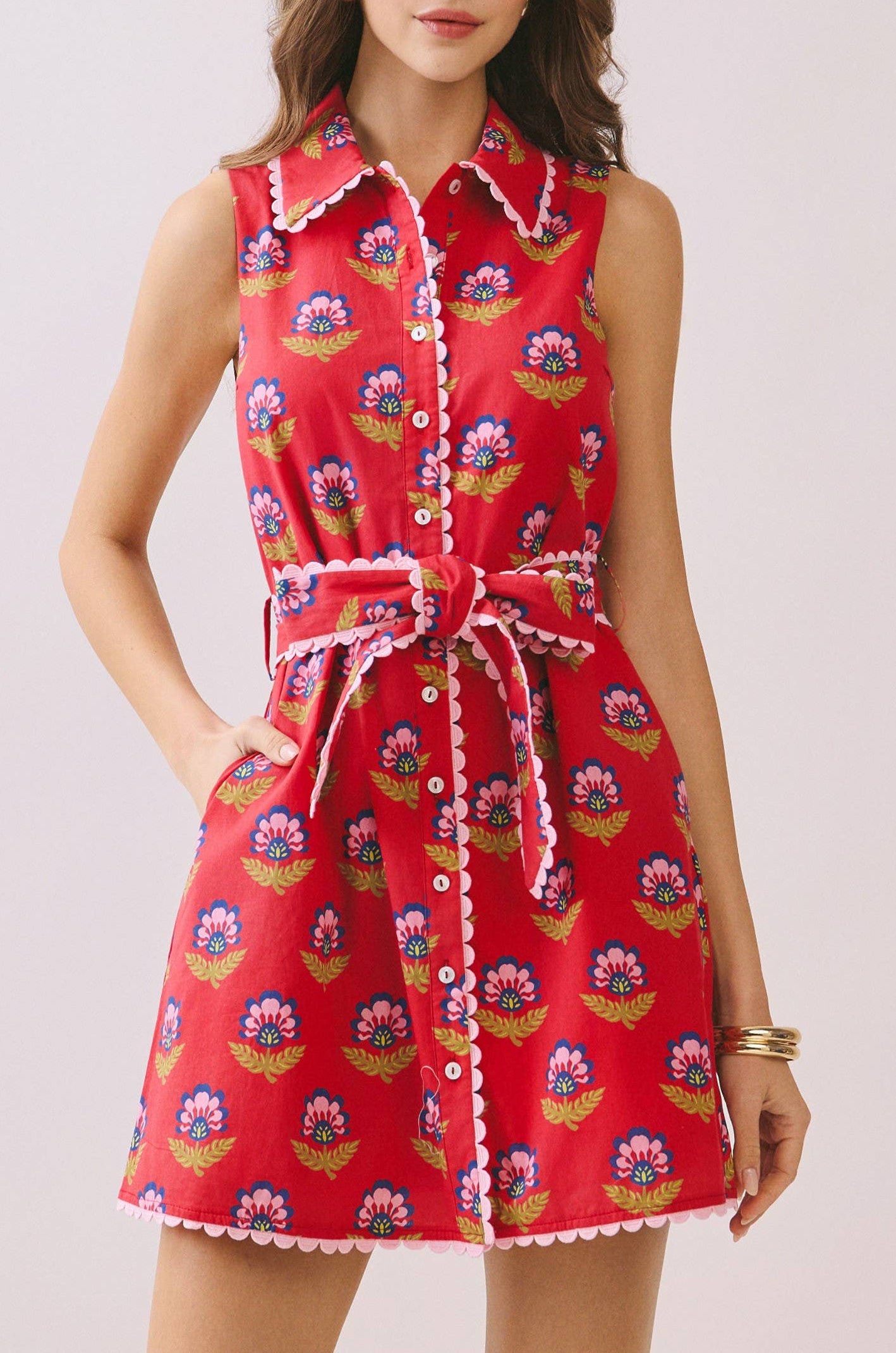 Woman wearing a red floral dress on a light background