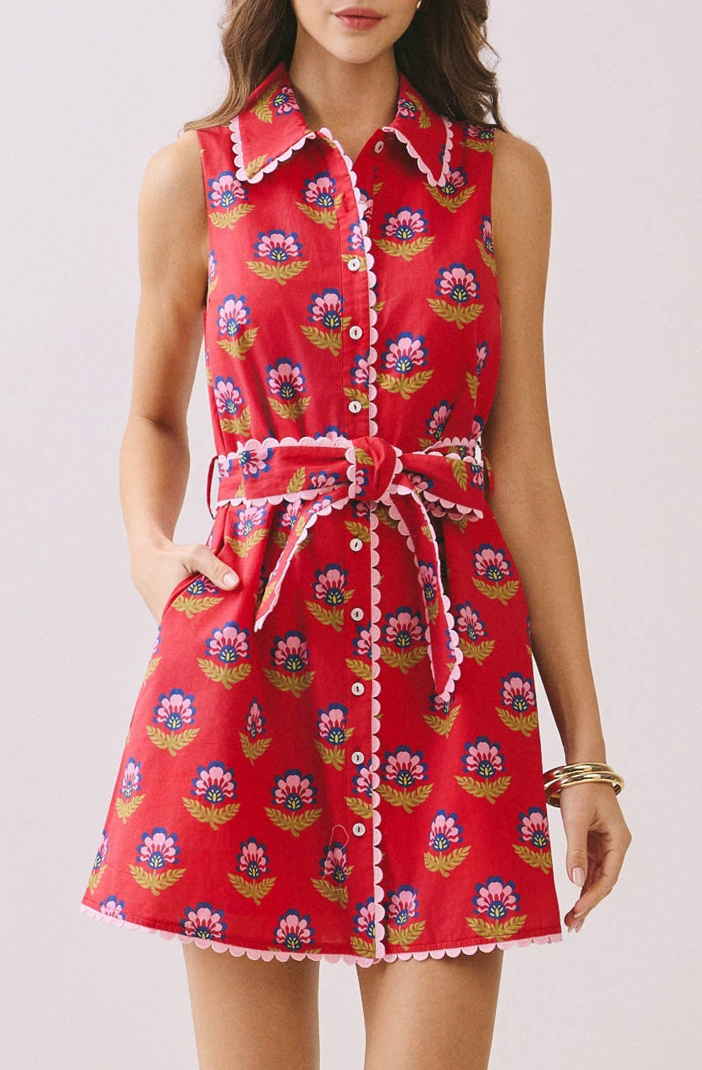 Woman wearing a red patterned dress on a white background