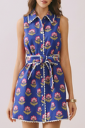 Woman wearing a blue floral dress on a light pink background