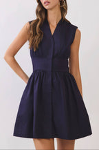 Woman wearing a navy blue dress against a white background