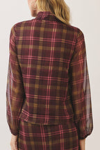 A woman shown from the back wearing a matching plaid long-sleeve top and skirt set. The fabric features a classic tartan pattern in dark red, brown, and yellow with thin pink stripes, set against a plain off-white studio background.