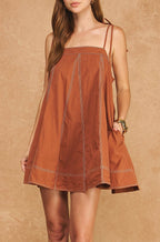 Woman wearing a brown dress against a matching background