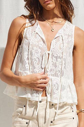 Woman wearing a white sleeveless top and cream skirt against a white backdrop