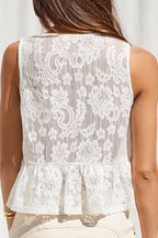 Woman wearing a white lace top against a white curtain background