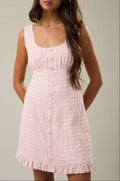 Woman wearing a pink dress against a neutral background
