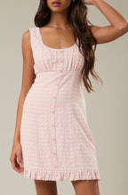 Woman wearing a pink dress against a plain background