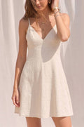 Woman wearing a white dress against a plain background